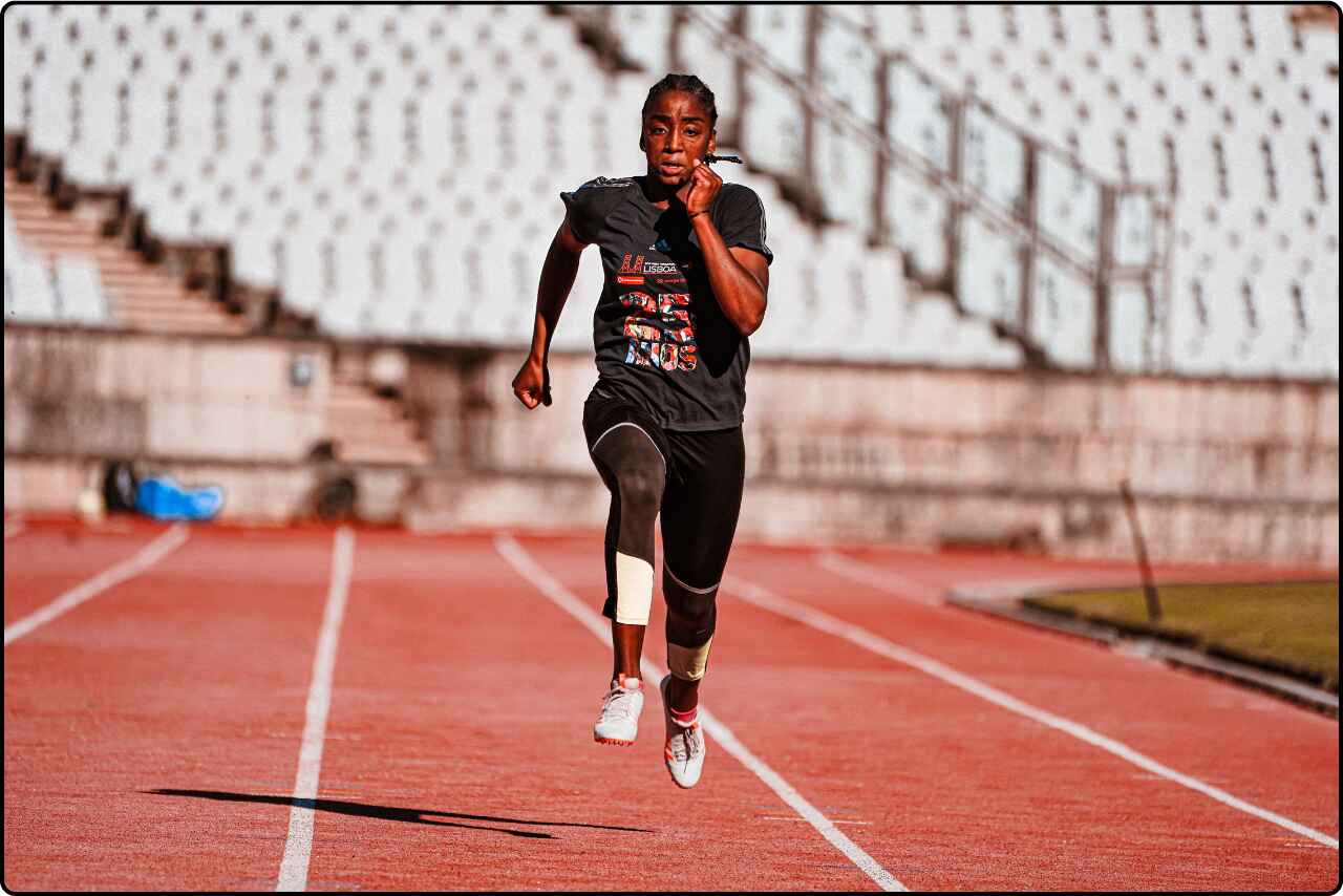 Sportsman running along the track in a stadium.